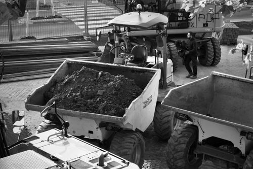 Free Black and white image of a construction site with machinery and a worker. Stock Photo