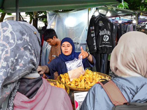 Free A woman selling pastries at an outdoor market booth during the day. Stock Photo