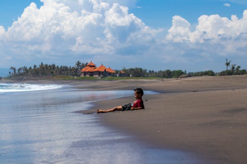 Child in Red Shirt Lying on Beach