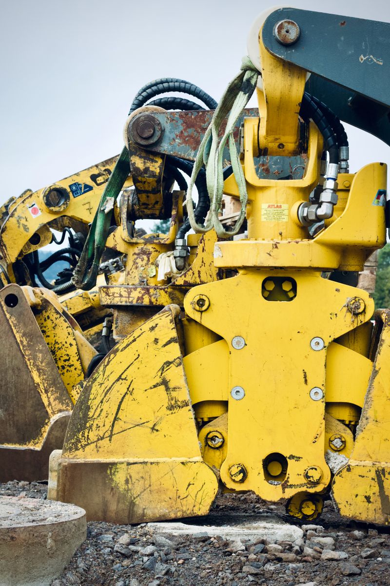 Detailed view of heavy-duty construction equipment with rust and dirt, showcasing industrial strength