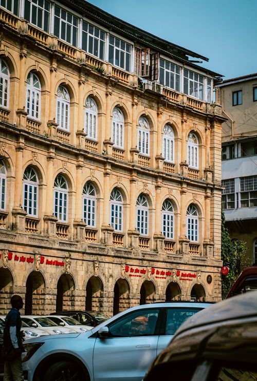 Free Capture of a historic building with cars and pedestrians in Mumbai, India. Stock Photo