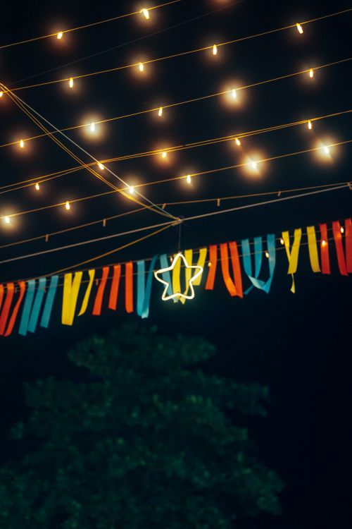 Free A vibrant night scene with hanging streamers and fairy lights creating a festive mood. Stock Photo