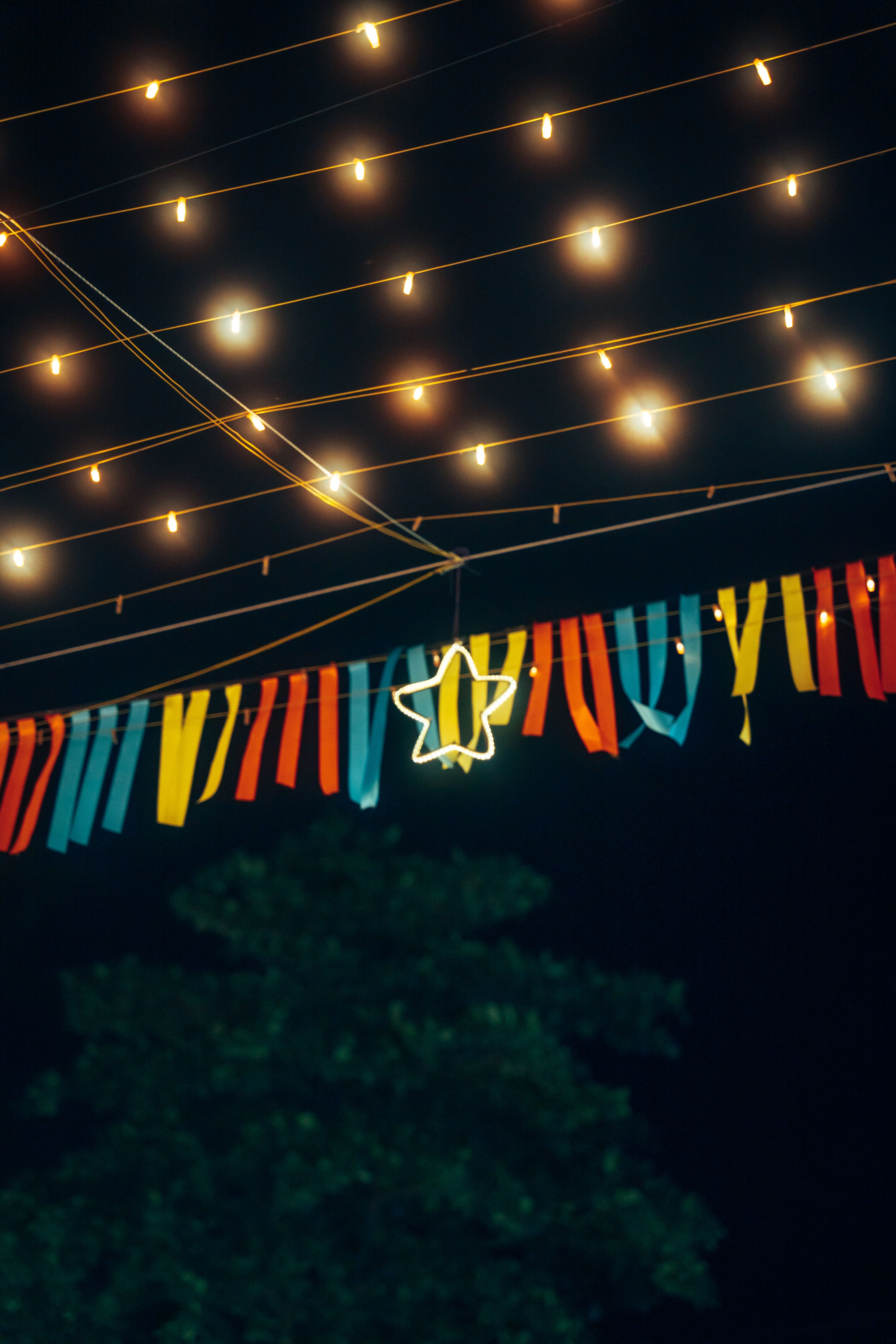 De franc Una escena nocturna vibrant amb serpentines penjants i llums de fades que creen un ambient festiu. Foto d'estoc
