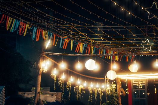 Outdoor string lights and decorations create a festive nighttime ambiance.