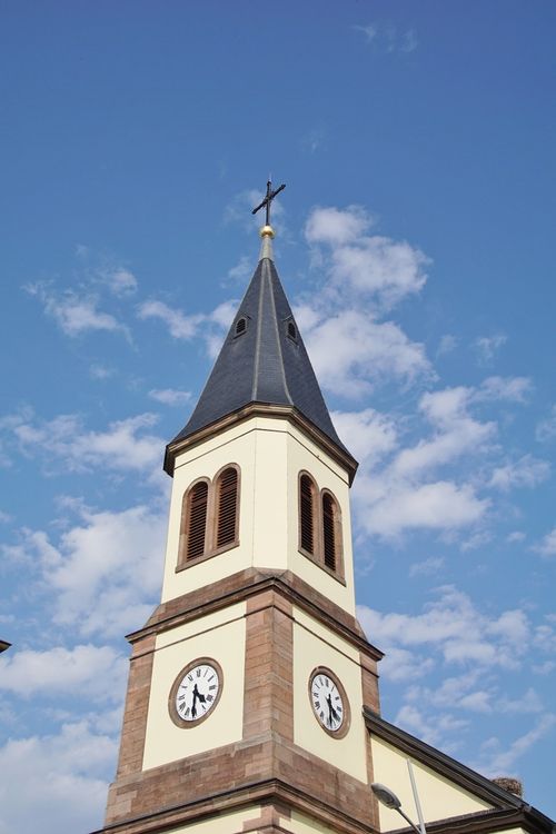 Free Beautiful church steeple against a blue sky in Bischwihr, showcasing architectural elegance. Stock Photo