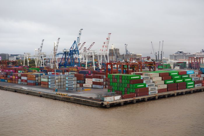 Stacked shipping containers at a busy port