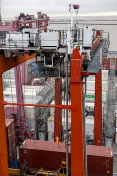 Aerial view of cargo containers and cranes at a busy industrial port.