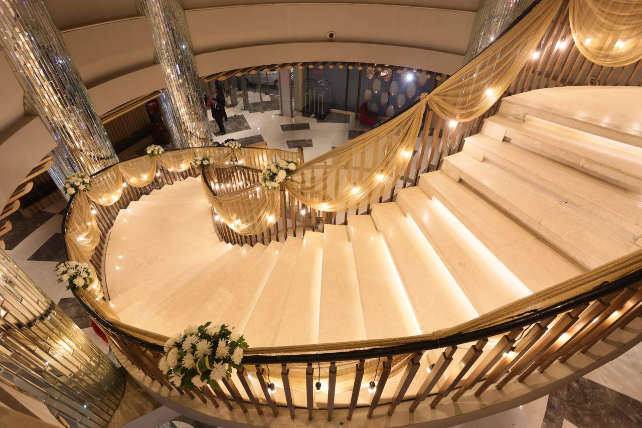 glamorous spiral staircase adorned with lights and floral decorations