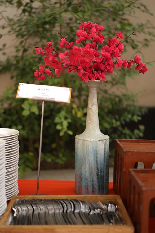 Free Elegant vase with red flowers on a buffet table with plates and cutlery. Stock Photo