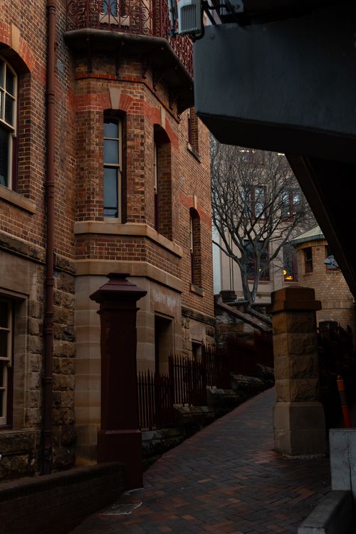 Free A narrow, historic alley in Sydney showcasing brick architecture and soft evening light. Stock Photo