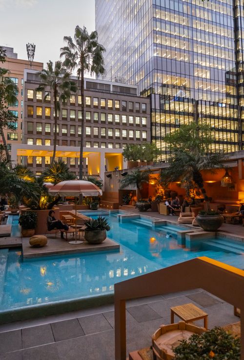Free Experience a serene evening by the pool in a luxurious urban setting at a Sydney hotel, surrounded by skyscrapers. Stock Photo