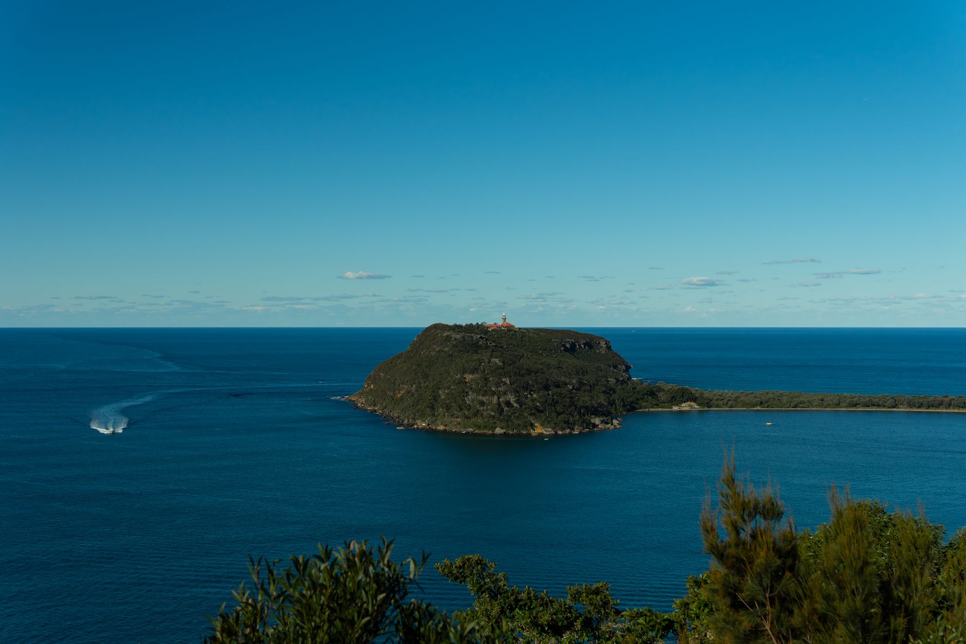 Breathtaking view of Barrenjoey Head and clear blue waters under a vibrant sky in Sydney, Australia.