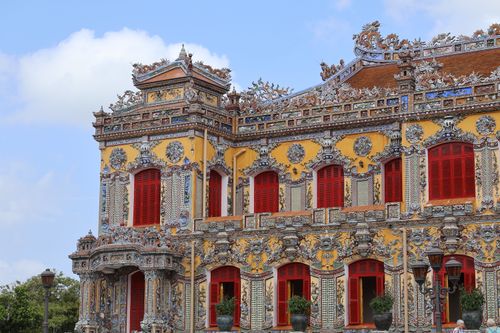 Free Stunning architectural details on an ornate Vietnamese building with vivid red windows under a clear sky. Stock Photo