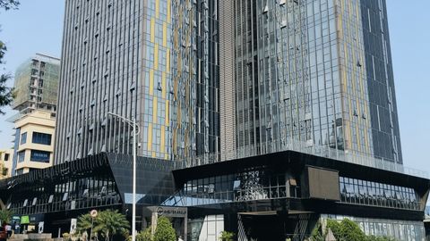 A contemporary view of the BPR Bank building showcasing modern glass architecture under clear skies.