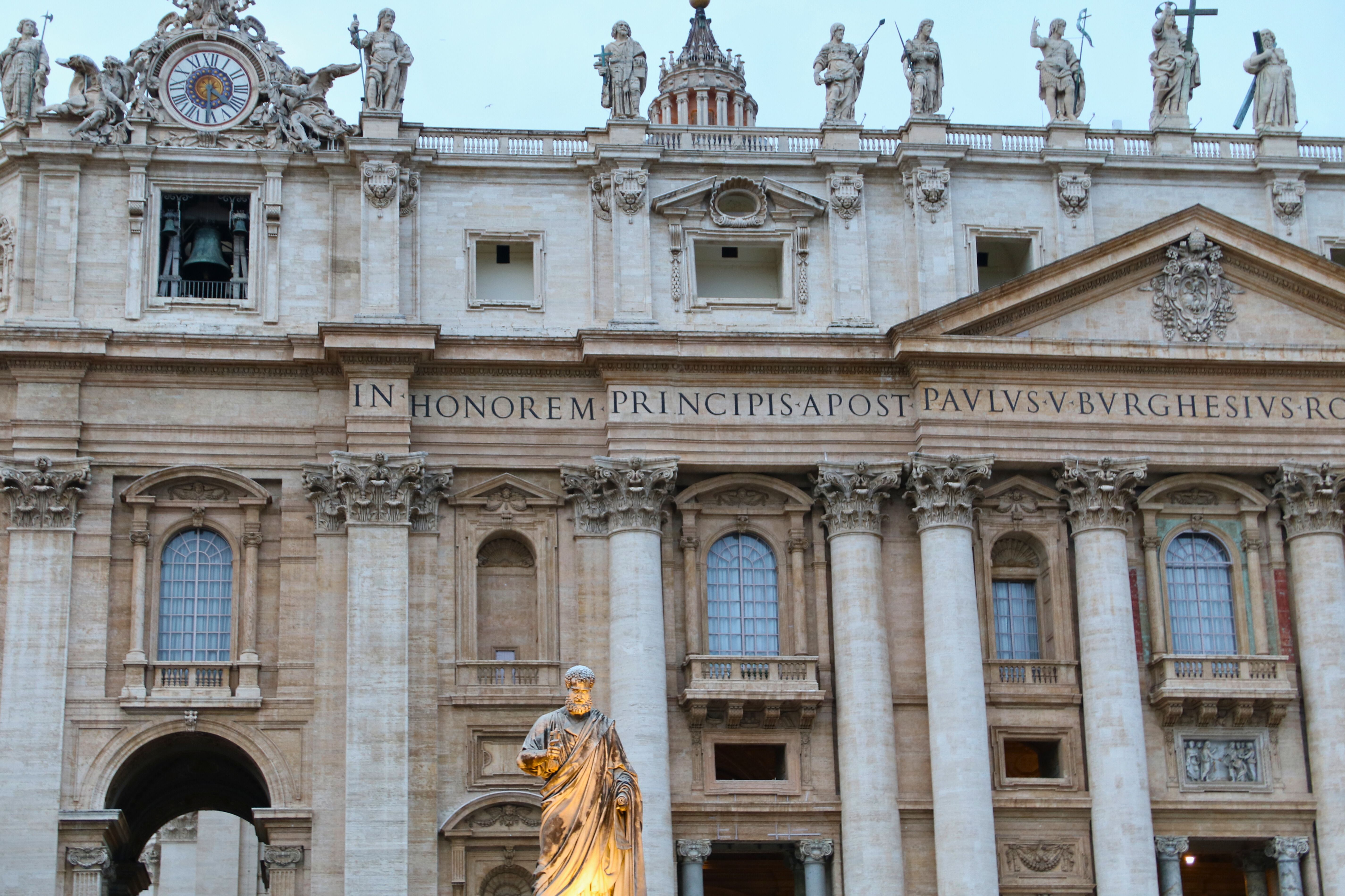 The majestic façade of St. Peter's Basilica in Vatican City, showcasing intricate architecture and historical statues.