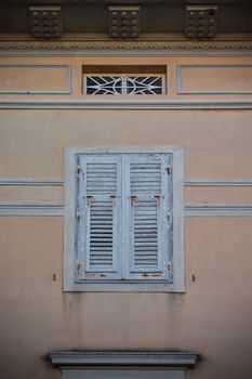 Weathered shutters on historic architecture in Grado, showcasing Italian charm.