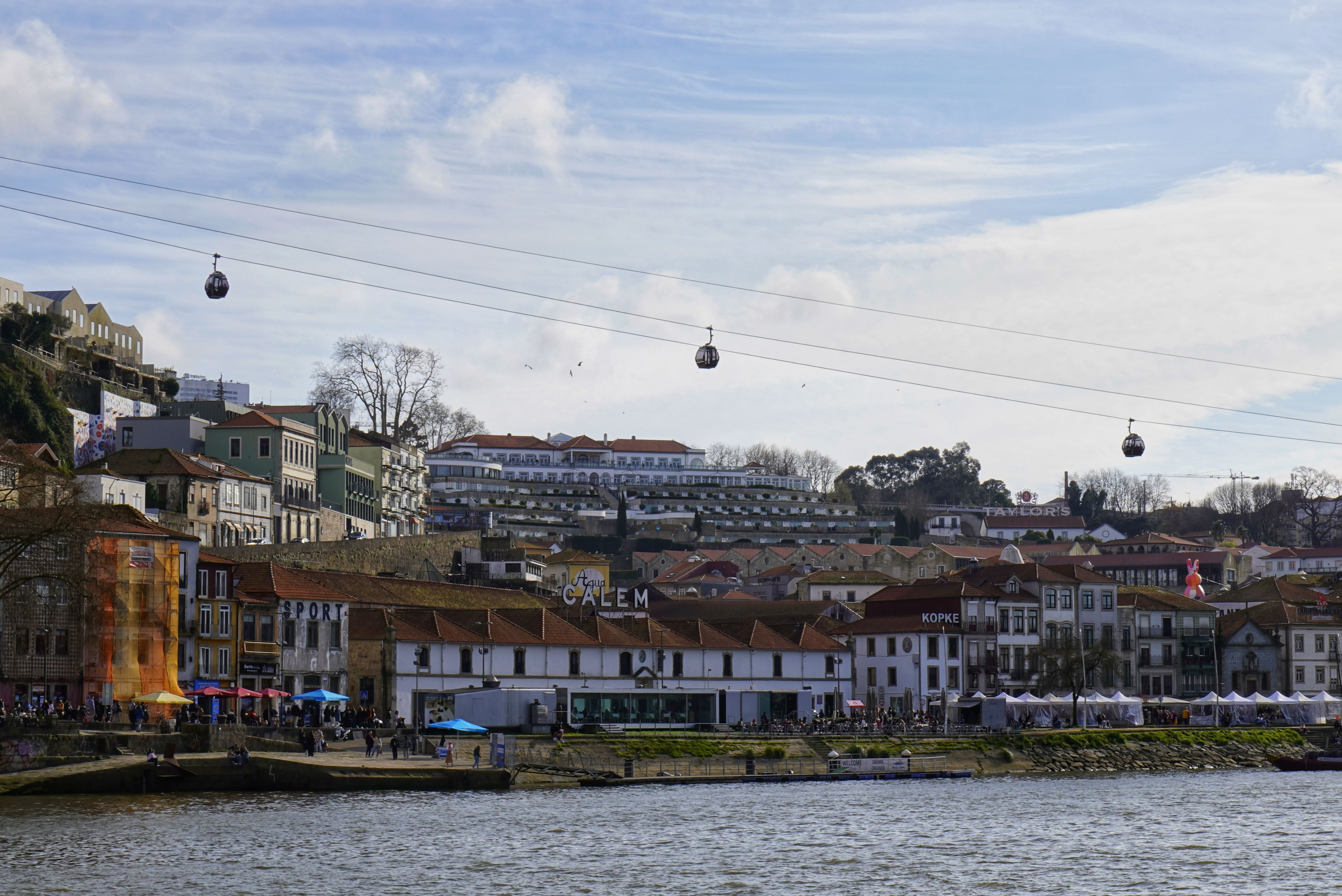 Vila Nova de Gaia hillside across the Douro showing painted port lodge signs