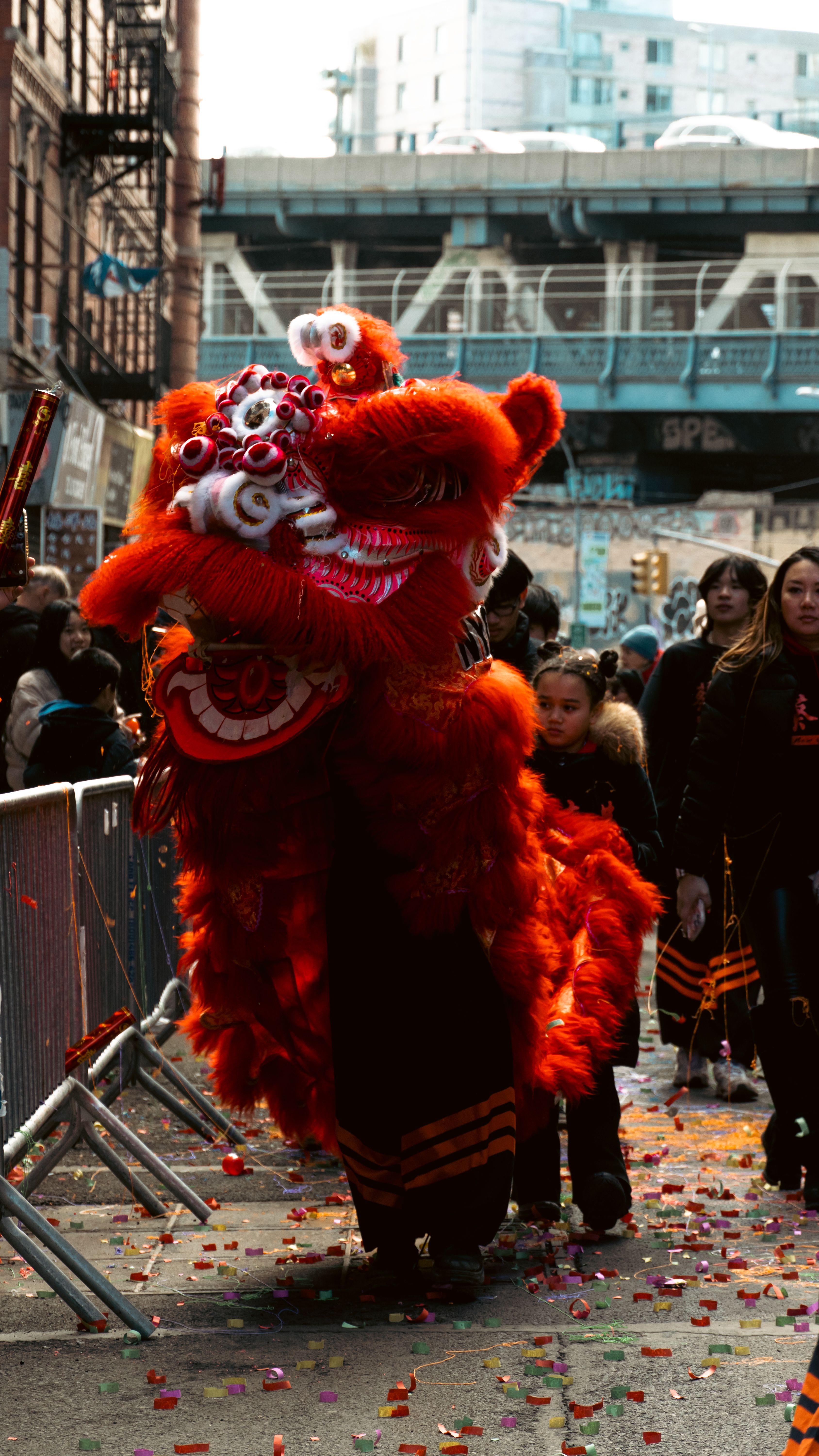 Colorful lion dance performance on city street during Chinese New Year celebration.
