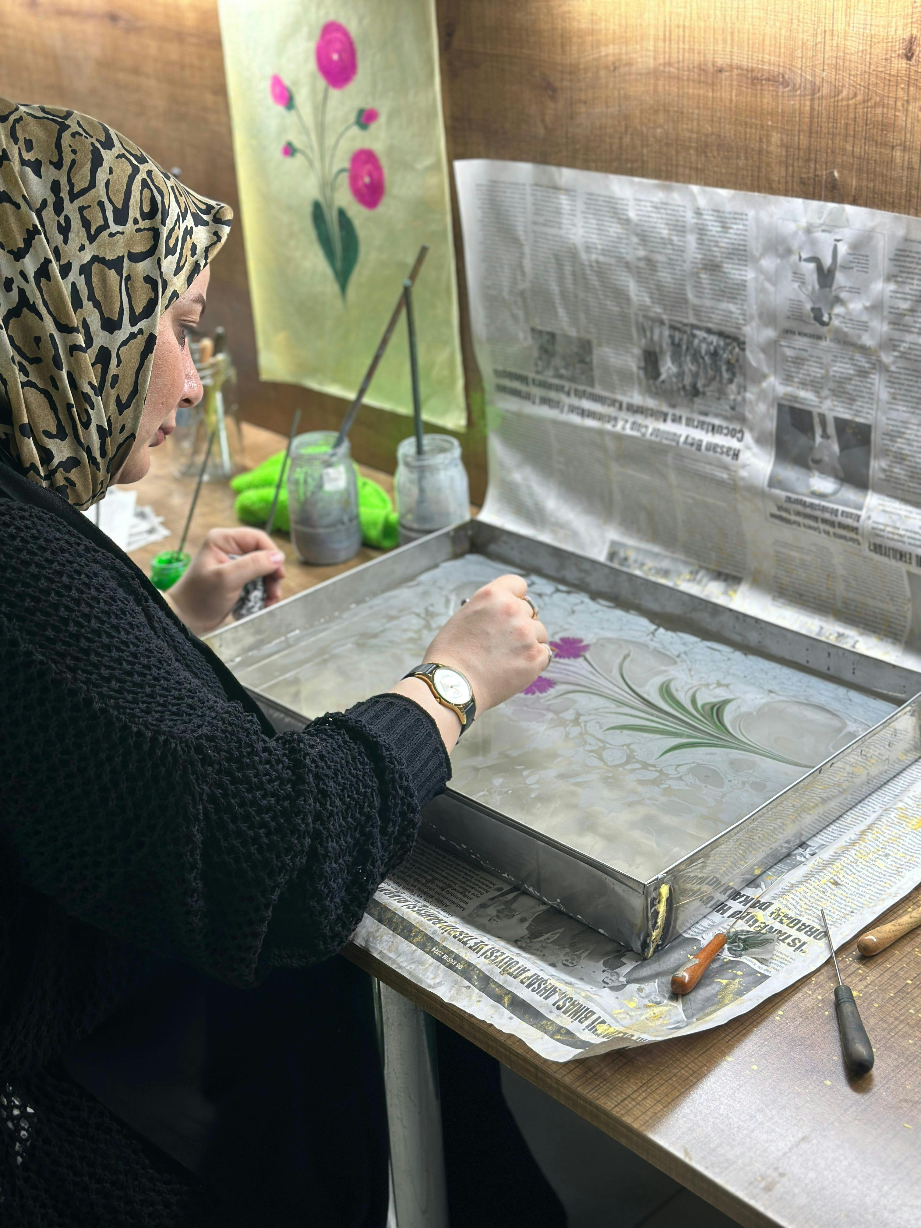 Artisan crafting intricate Ebru patterns on water using traditional techniques.