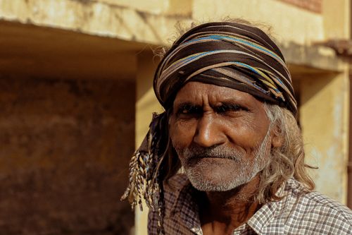Free Close-up portrait of an elderly man wearing a colorful headscarf, conveying wisdom and character in natural lighting. Stock Photo