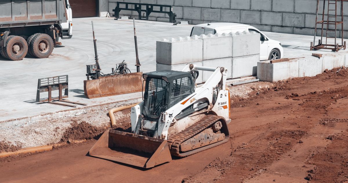 Bulldozer with front loading blade working on a construction site — the same front-blade principle that defines the self-loading mini dumper