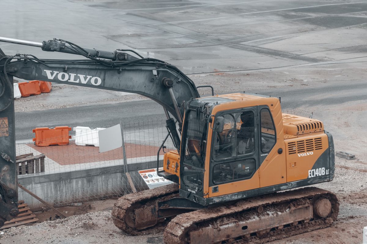 Bedrock Excavation's yellow Volvo excavator parked on a muddy work site