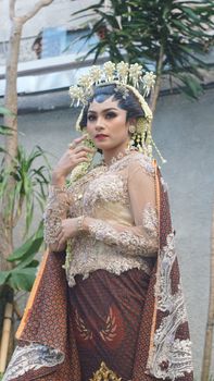 A striking portrait of an Indonesian bride in elaborate traditional attire with intricate makeup. - Fotografer Sidoarjo