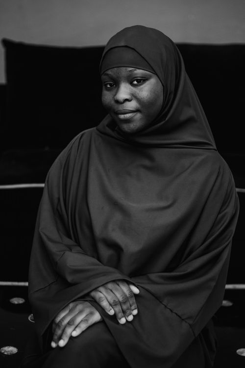 Free Elegant black and white portrait of a woman wearing a hijab, seated indoors. Stock Photo