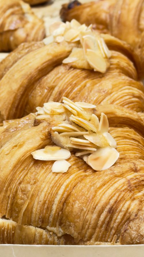 Free A detailed view of golden almond croissants with sliced almonds, ideal for bakery marketing. Stock Photo