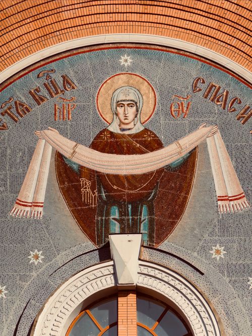 Free Detailed mosaic of a religious figure on a brick wall facade, showcasing intricate art and symbolism. Stock Photo
