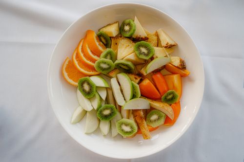 Bowl of mixed cut fruit on a white cloth — photo by Paolo Bici on Pexels