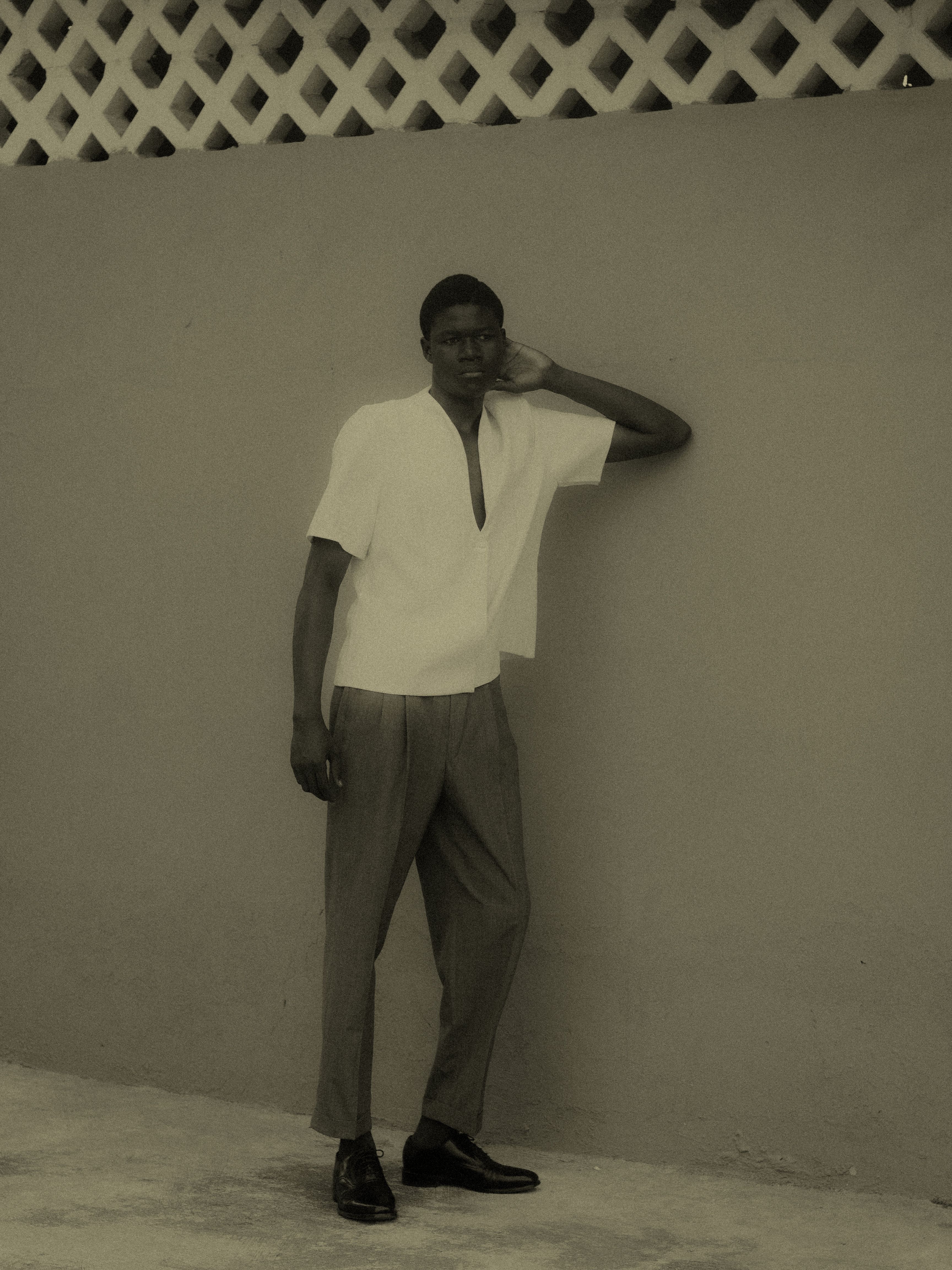Stylish Man Posing Against a Textured Wall · Free Stock Photo