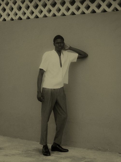 Free Fashionable man in a vintage pose by a textured wall in sepia tone. Stock Photo