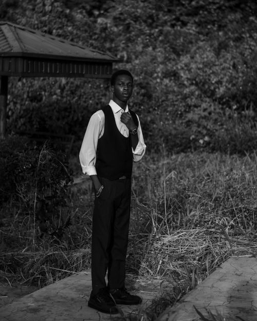 Free Monochrome portrait of an elegantly dressed man standing in a natural outdoor setting. Stock Photo