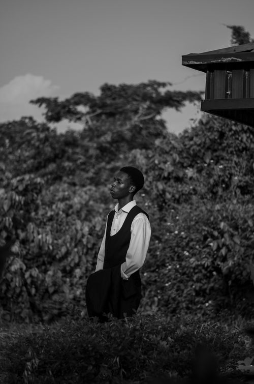 Free A thoughtful adult male in formal attire gazing outdoors, captured in black and white. Stock Photo