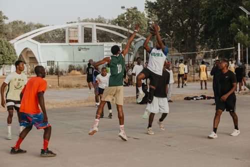 Free Young men playing a dynamic outdoor basketball game in Nigeria's lively sports setting. Stock Photo