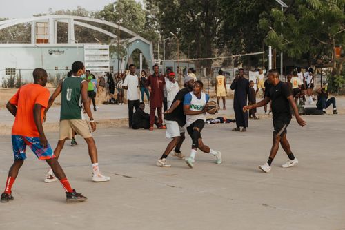 Free Exciting outdoor basketball game with players in action surrounded by a lively crowd. Stock Photo