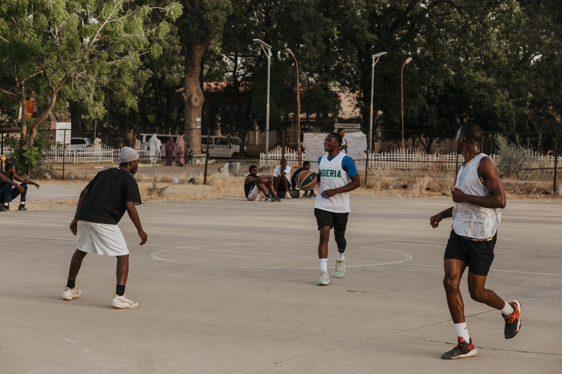 basketball guard attacking a cone course in a full gym, motion blur showing a sharp crossover and explosive first step