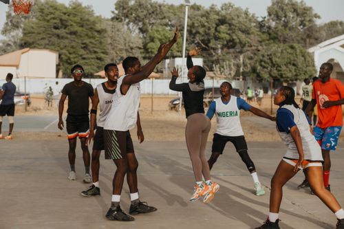 Free A lively basketball match takes place outdoors with players showcasing dynamic moves. Stock Photo