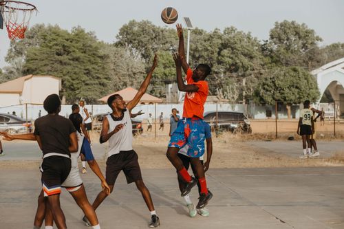 Free Dynamic outdoor basketball game with young men engaging in play, showing athletic skills. Stock Photo