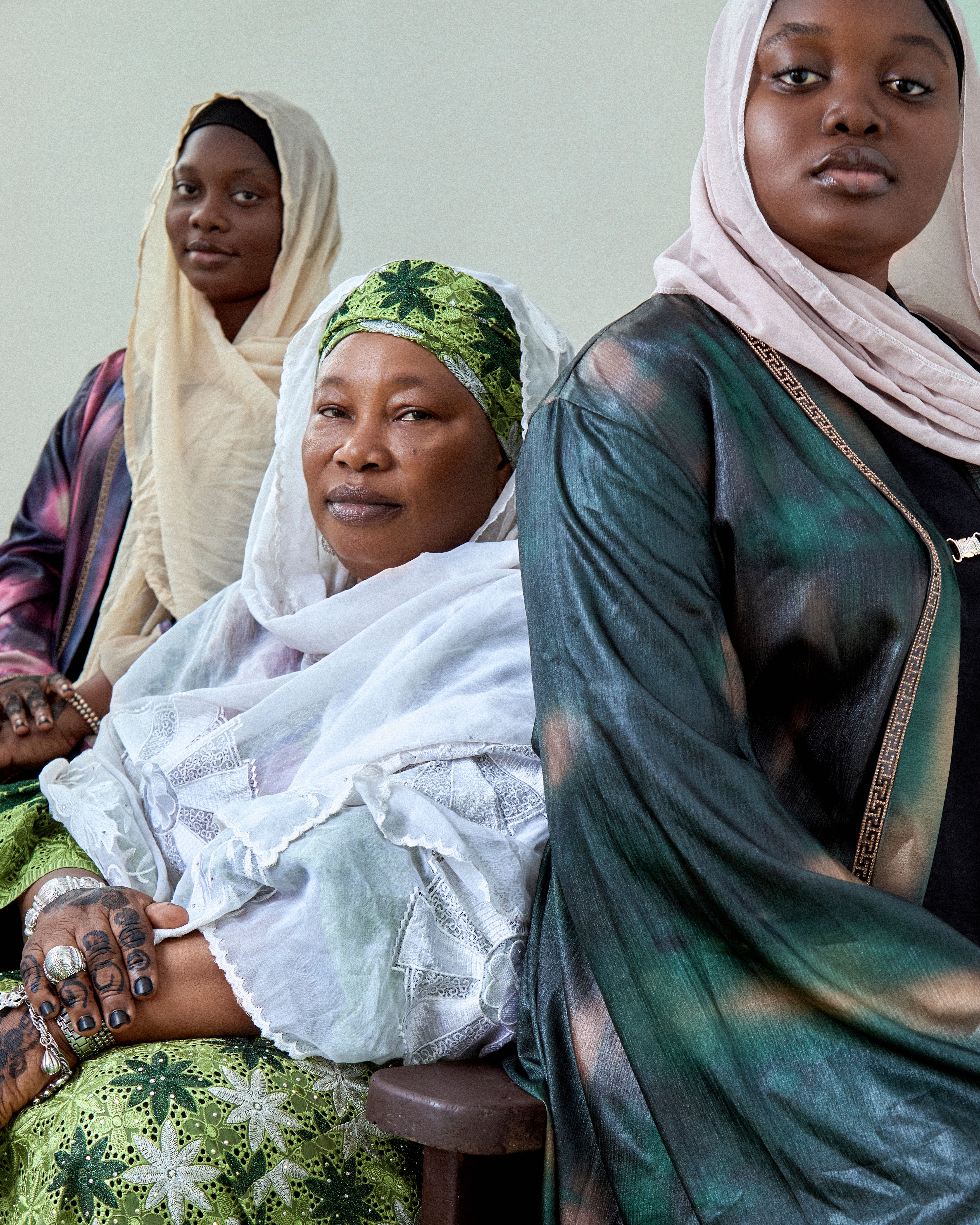Three Nigerian women in traditional attire showcasing cultural heritage and style.