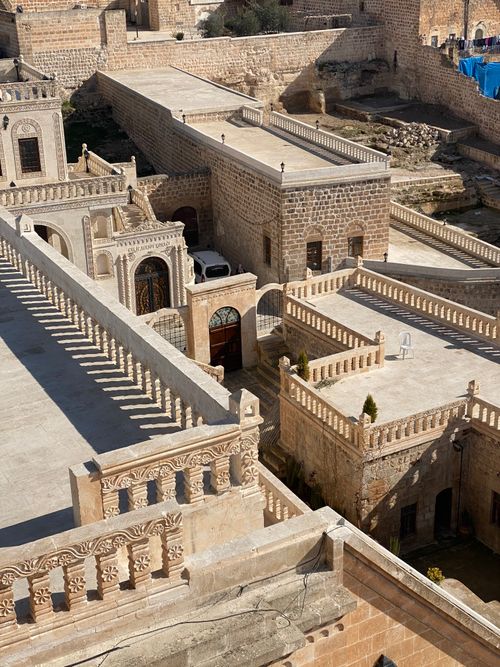 Free Aerial view of historic stone buildings with intricate architectural details bathed in sunlight. Stock Photo