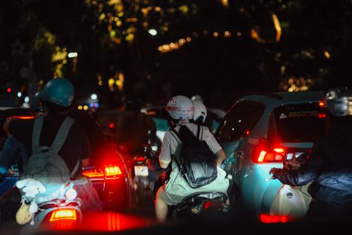 Free Crowded night street filled with motorbikes and cars showcasing urban nightlife. Stock Photo