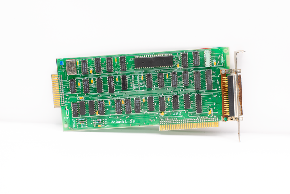 Close-up of a vintage computer circuit board highlighting chips and connectors.
