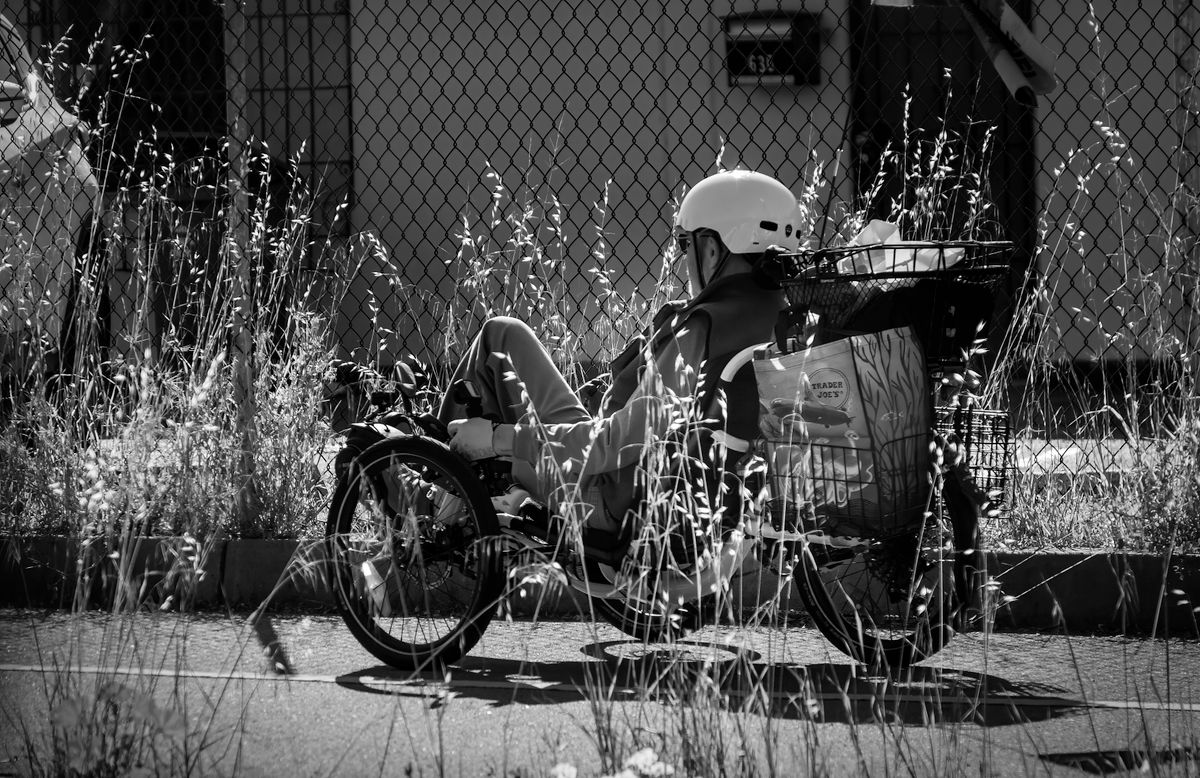 Cyclist riding a recumbent bicycle through an urban environment