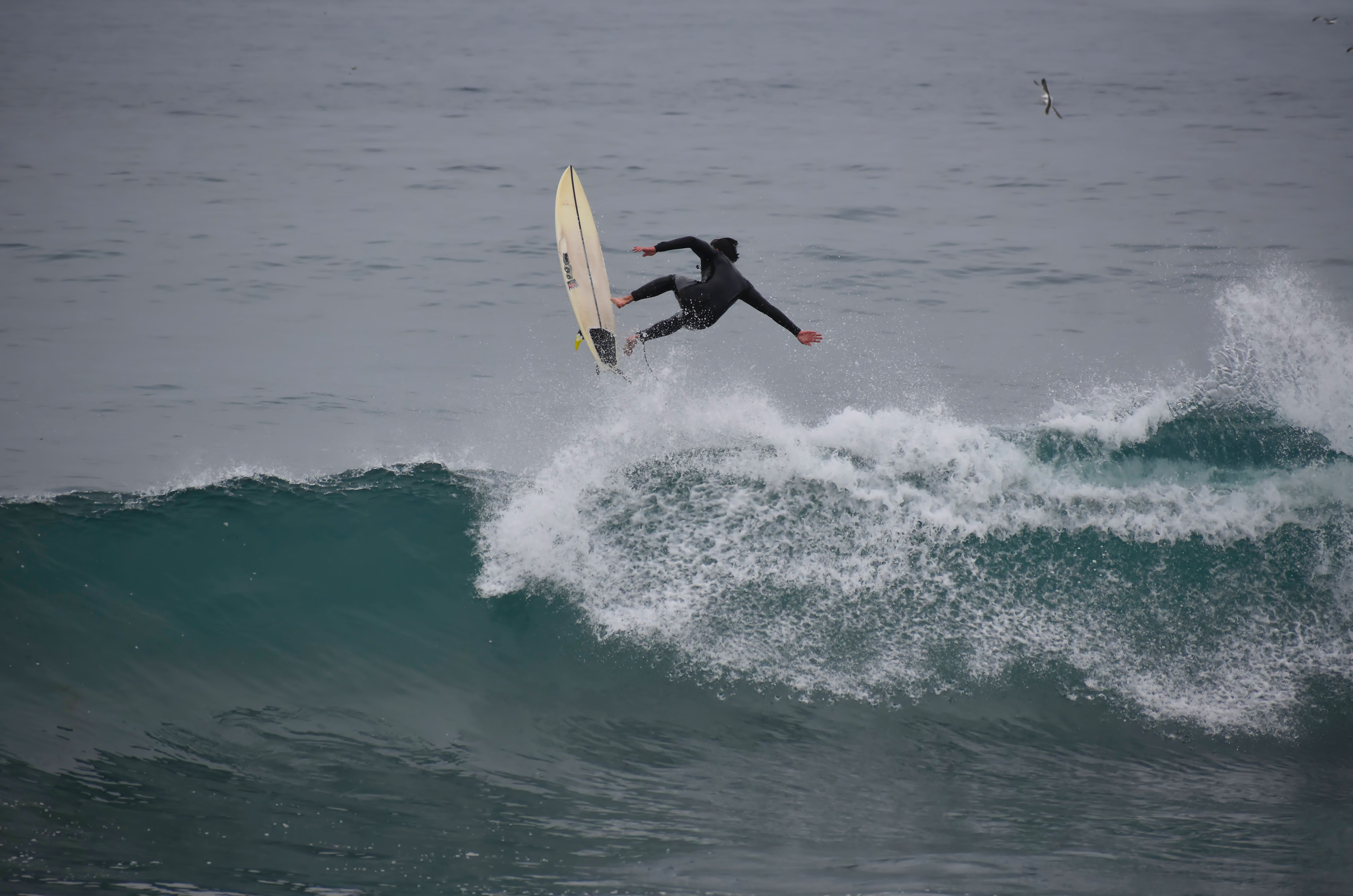 Surfer Performing Aerial Maneuver Over Ocean Wave · Free Stock Photo