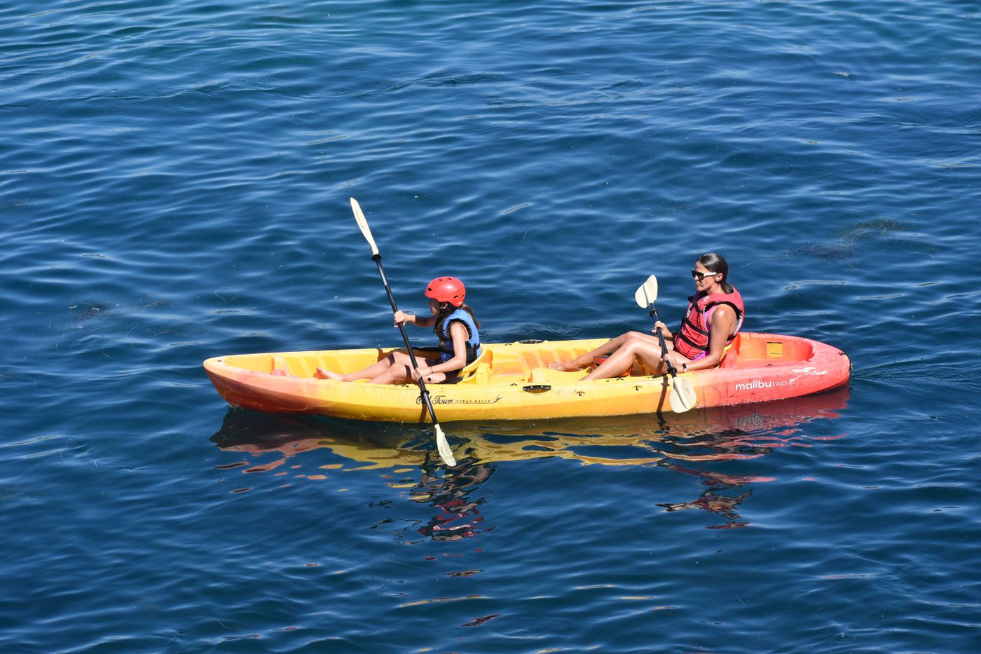 Adult and child kayaking together on open water