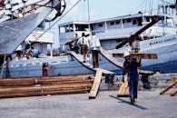 Workers Loading Timber onto Ships at Indonesian Port