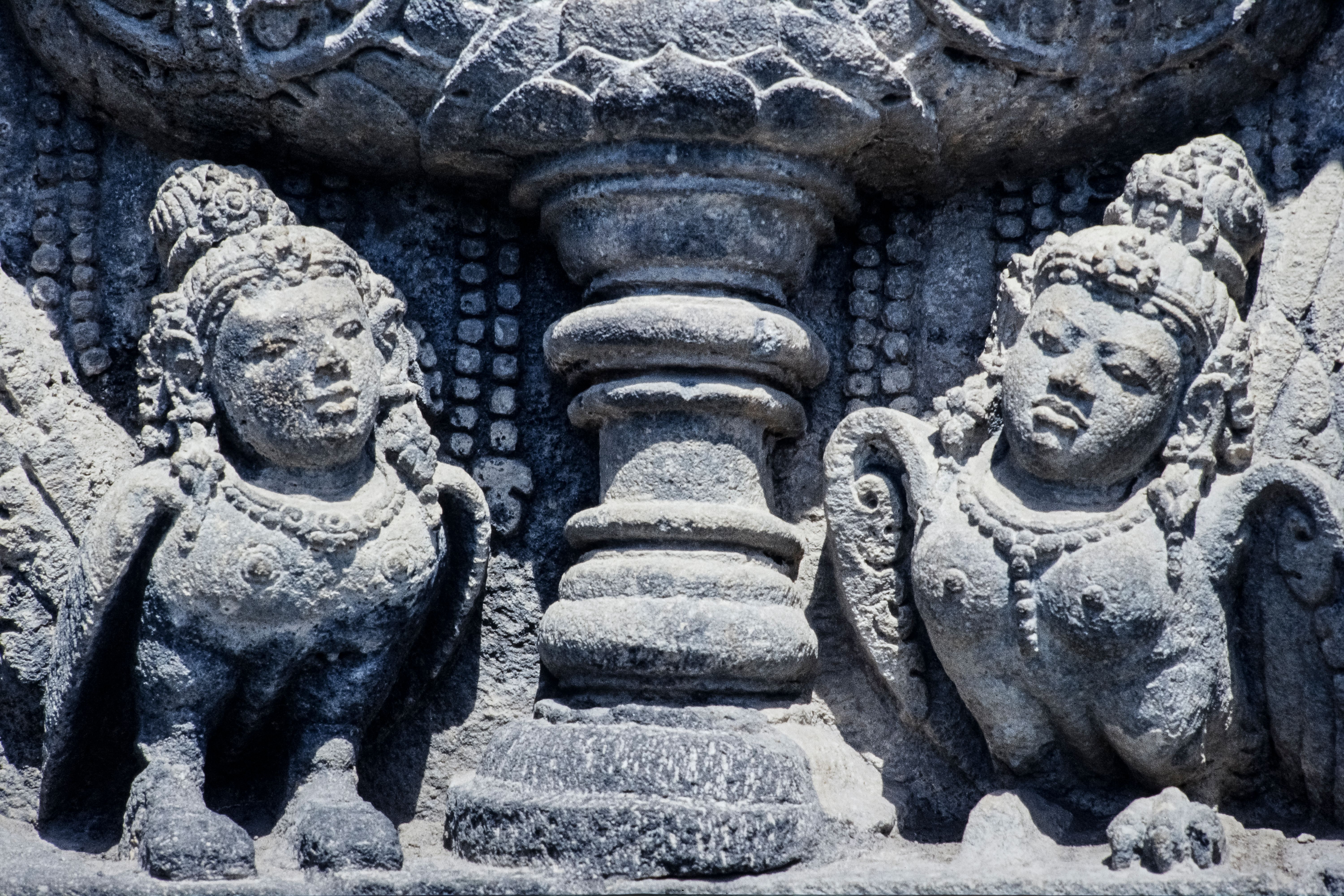 Close-up of detailed stone carvings depicting mythological figures on an ancient temple wall