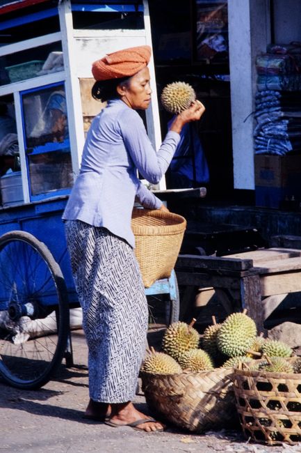 Indonesian woman sells durians at a traditional market street, Indonesia.